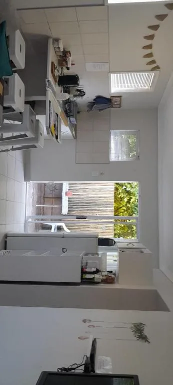 Bright kitchen with white cabinetry, sink, and natural light from windows