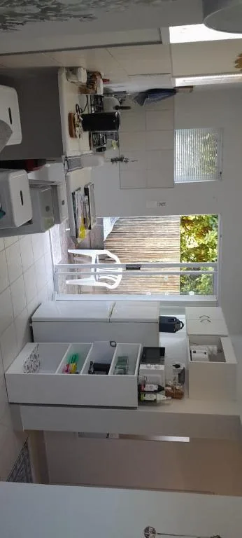 Compact kitchen with sink, stove, and organized storage drawers
