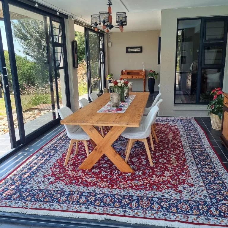 Wooden dining table with white chairs in bright, airy space