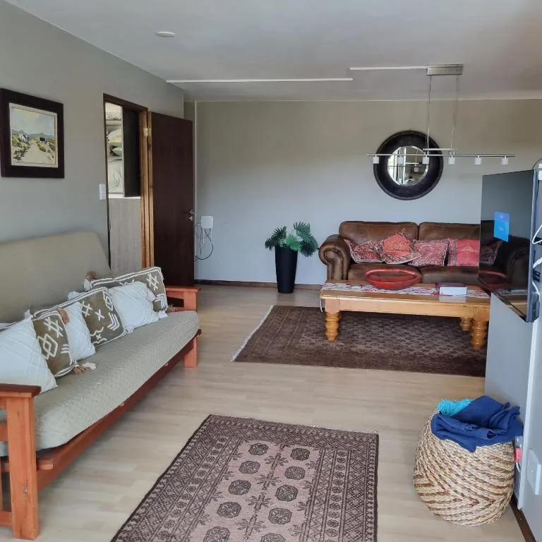 Spacious lounge with comfortable sofas, wooden coffee table, and modern lighting fixtures