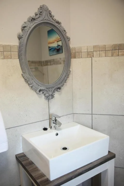 Elegant bathroom vanity with ornate mirror and white vessel sink