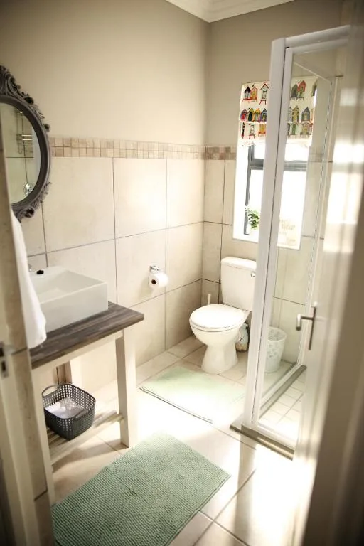 Clean bathroom with toilet, vanity sink, and glass shower enclosure