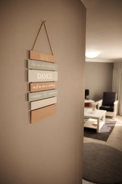Wooden motivational sign with text hung on cream wall