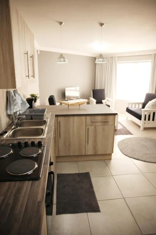 Modern kitchen with stove, sink, and island counter in open-plan apartment