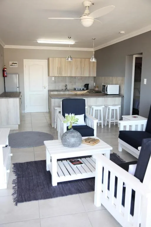 Modern lounge with comfortable seating, coffee table, and open-plan kitchen area