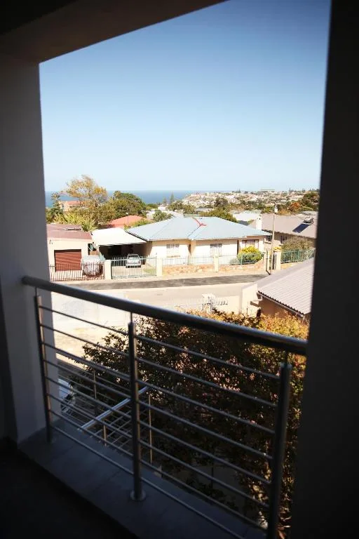 Ocean and coastal town vista from modern balcony with railing