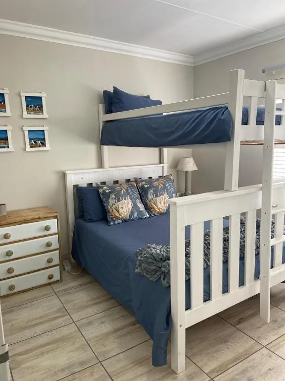 Bright bedroom with white bunk beds and navy blue bedding