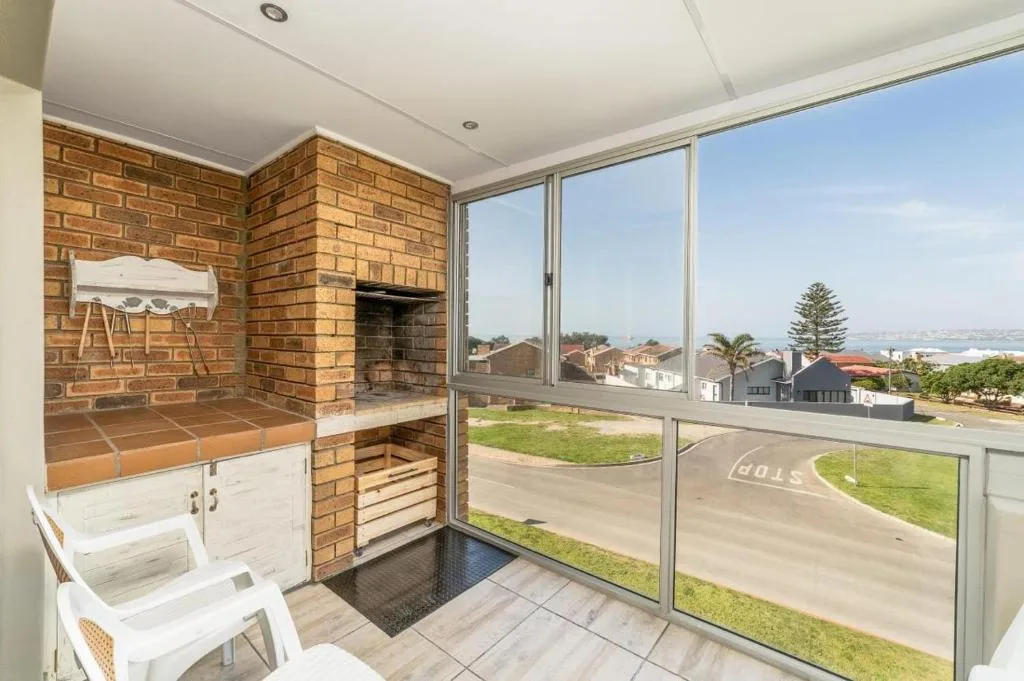 Covered patio with brick braai fireplace and ocean view doors
