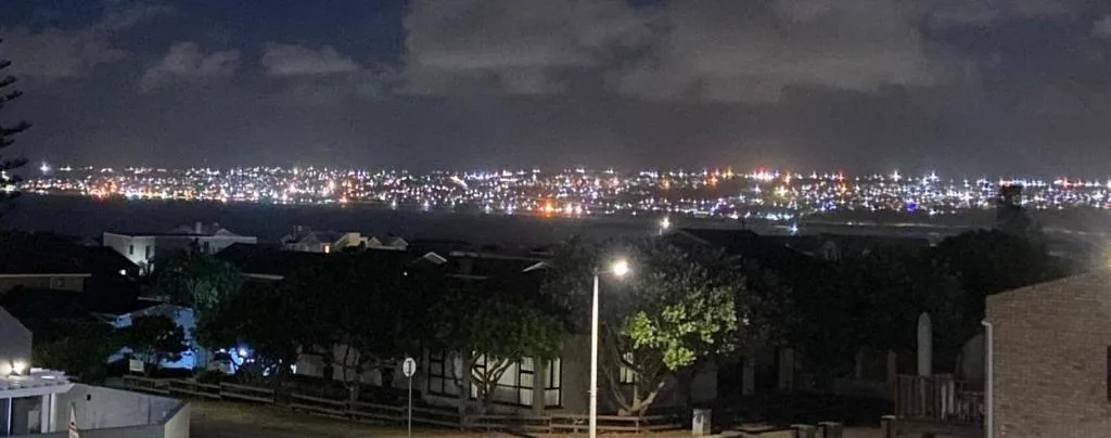 Nighttime city lights of Mossel Bay visible from property vantage point