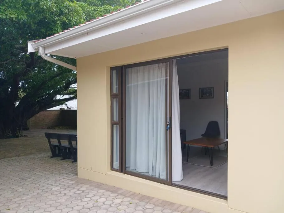 Cream cottage exterior with patio area and sliding glass doors opening to lounge