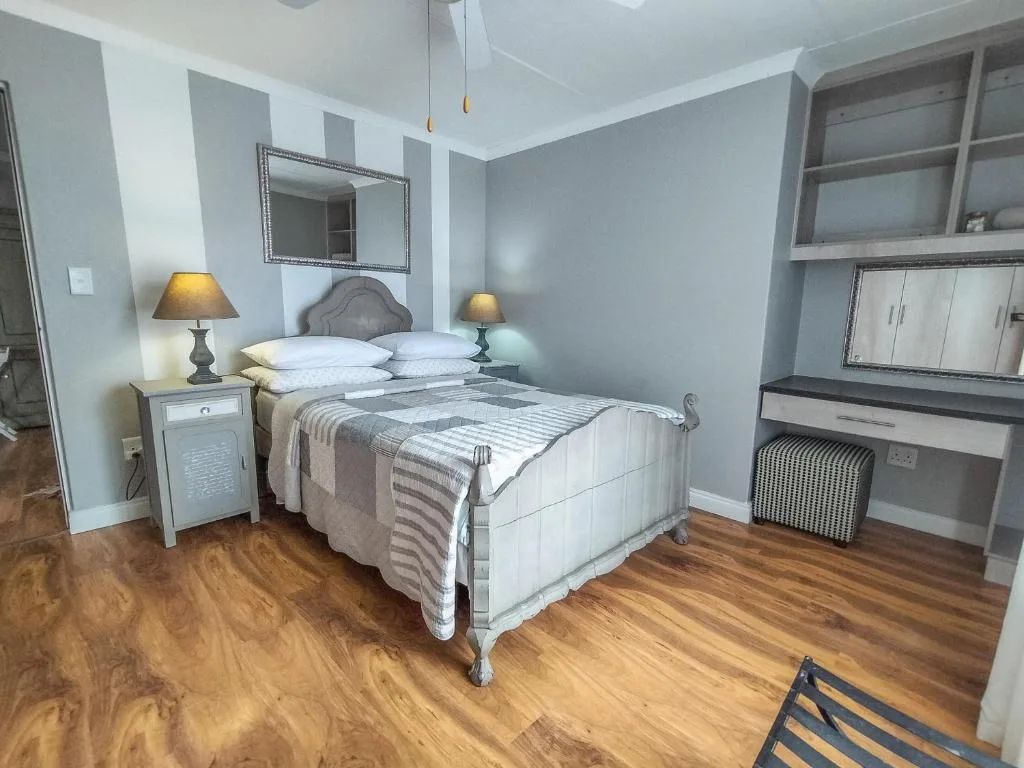 Spacious bedroom with white metal bed frame and matching nightstands with lamps