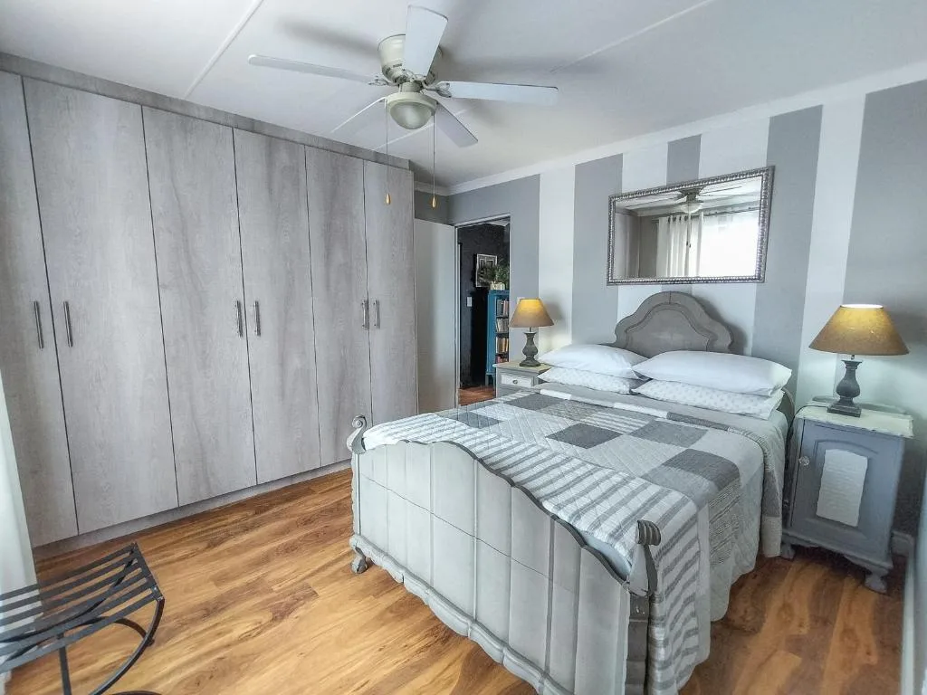 Spacious bedroom with queen bed, built-in wardrobes, and side lamps