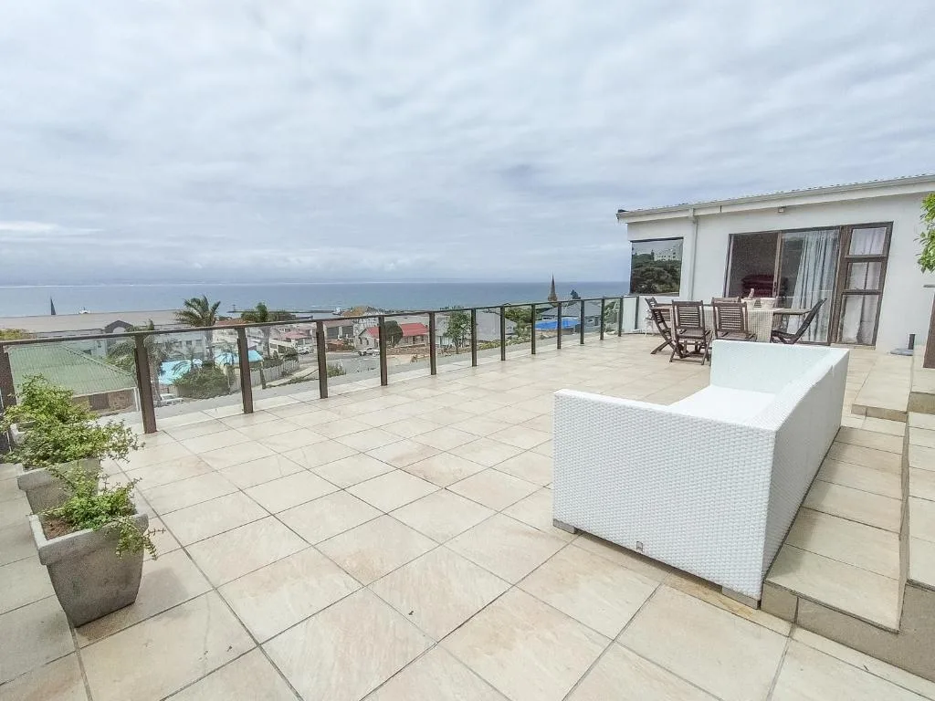 Spacious patio with ocean view, white storage, and lounge chairs
