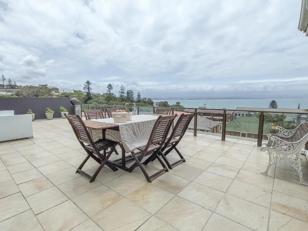 Spacious rooftop terrace with dining table, ocean and lagoon views