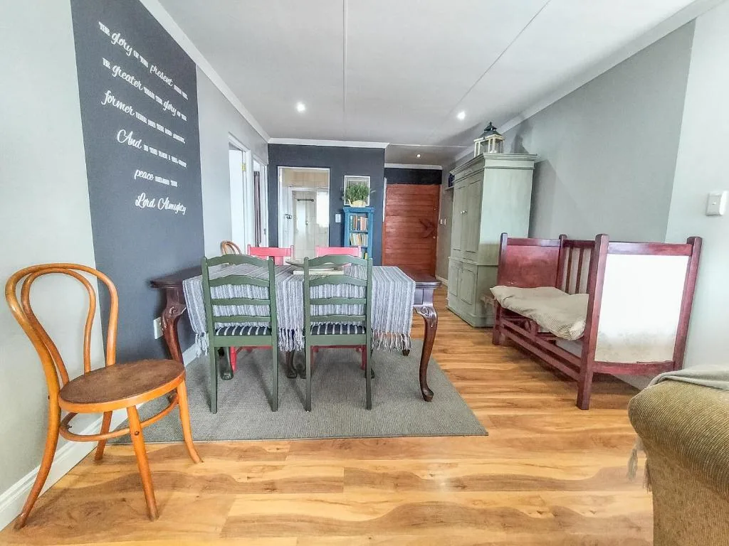 Open-plan lounge and dining area with wooden floors and eclectic furnishings