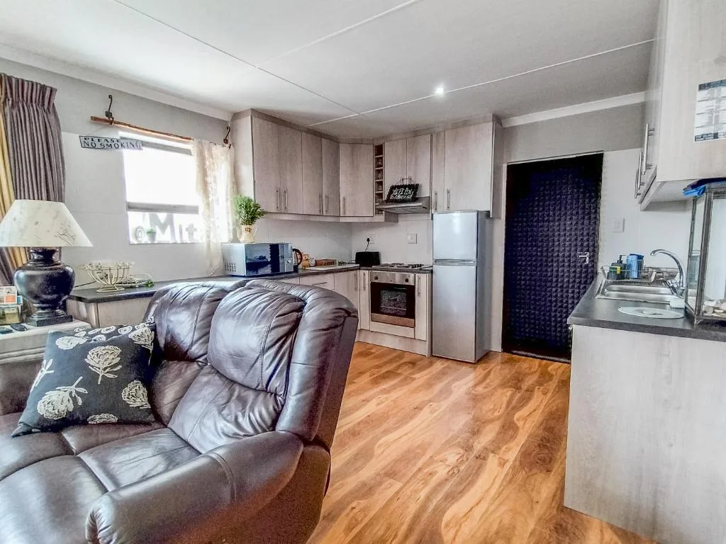 Open-plan lounge with leather sofa and integrated kitchen area