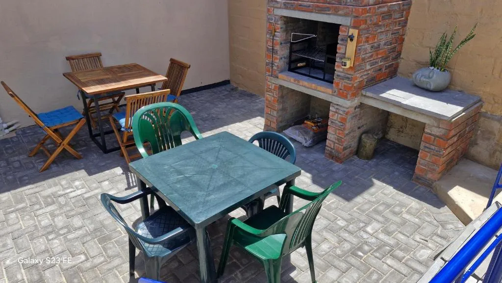 Outdoor patio with dining tables, brick fireplace, and seating area