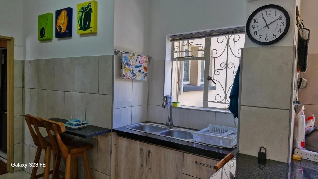 Kitchen with sink, stove, counter space and decorative wall art