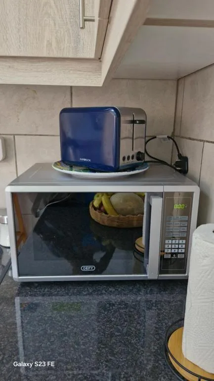 Kitchen counter with microwave, blue kettle, and toaster appliances
