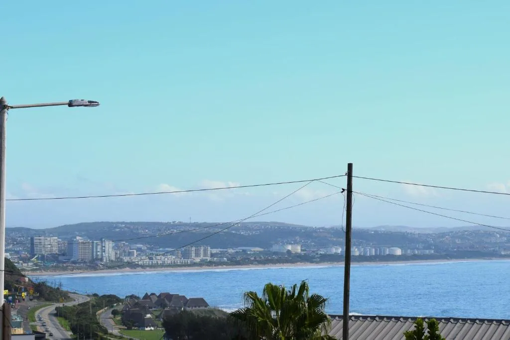 Scenic coastal view of Mossel Bay with beach, blue ocean, and distant buildings