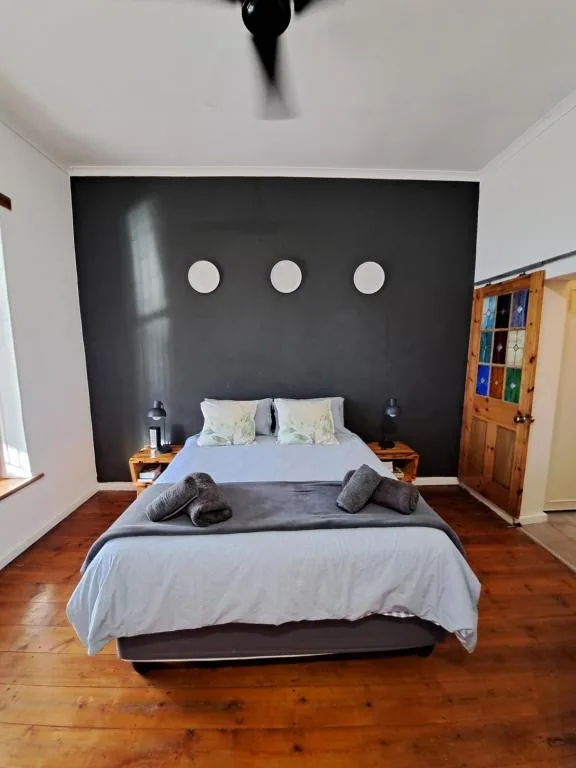 Modern bedroom with black accent wall and wooden floors throughout