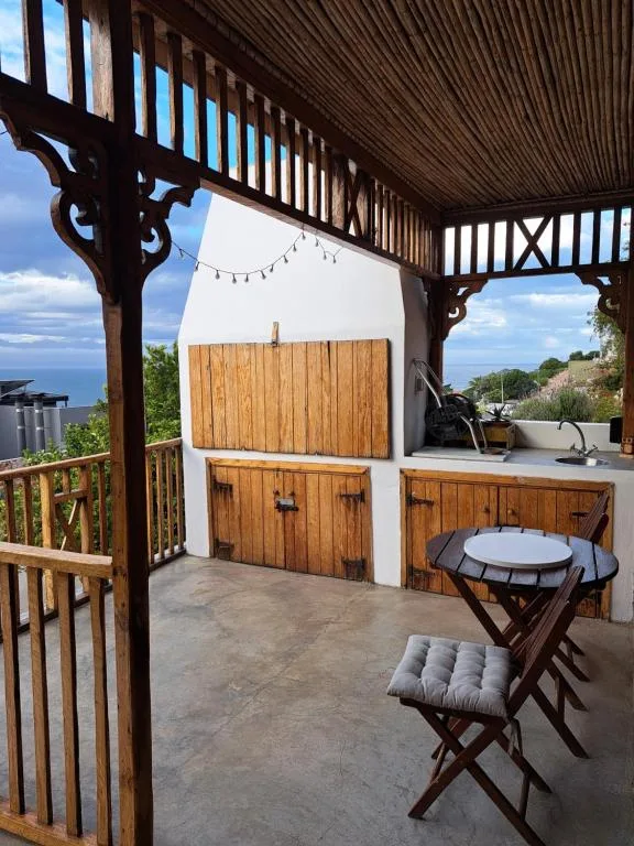 Covered outdoor patio with seating, braai area, and ocean views