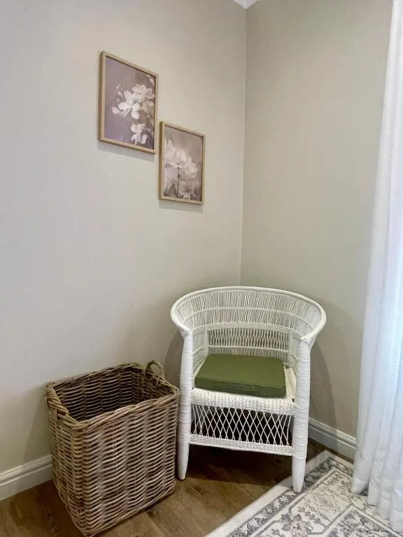 White wicker crib with green mattress and woven storage basket in corner