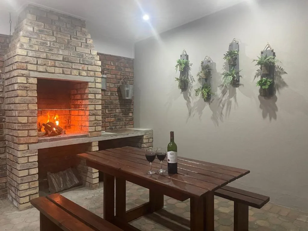 Indoor fireplace with wooden dining table and hanging plants on wall