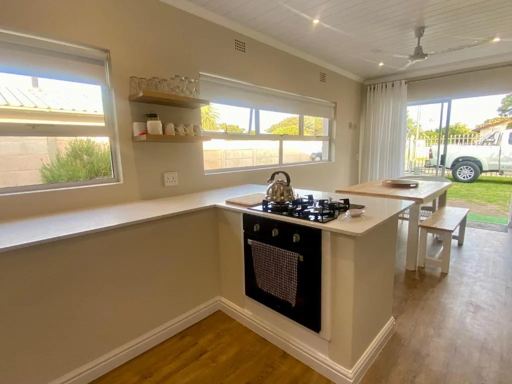 Modern kitchen with island, gas cooktop, and abundant natural light from windows