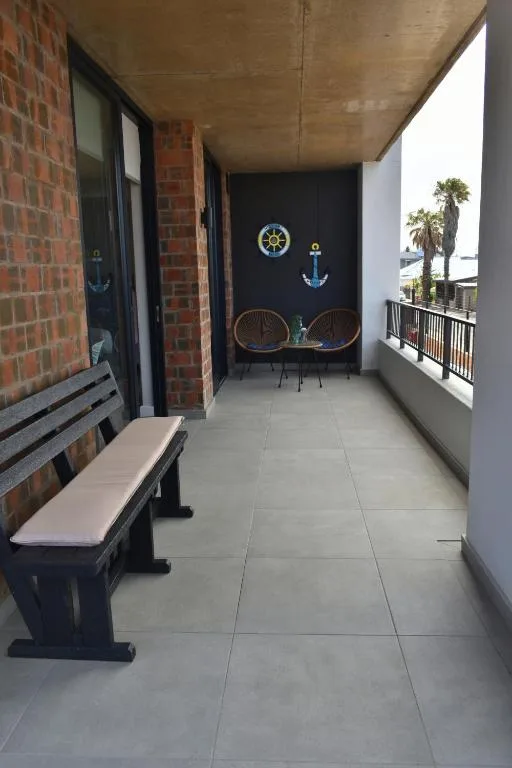 Covered balcony with bench seating, nautical decor, and ocean views