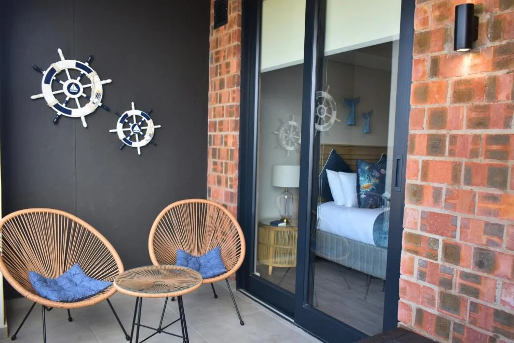 Outdoor seating area with woven chairs and nautical wheel decor