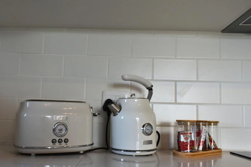 White subway tile kitchen counter with vintage-style toaster and kettle appliances