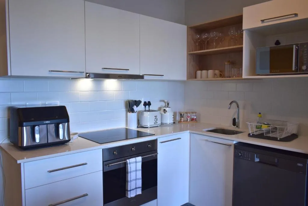Modern kitchen with white cabinetry, black appliances, and subway tile backsplash