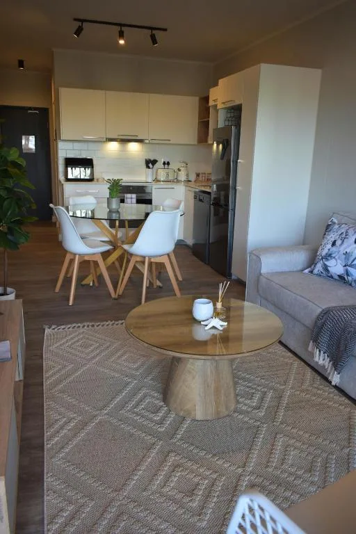 Open-plan lounge with round wooden table and modern sofa seating area