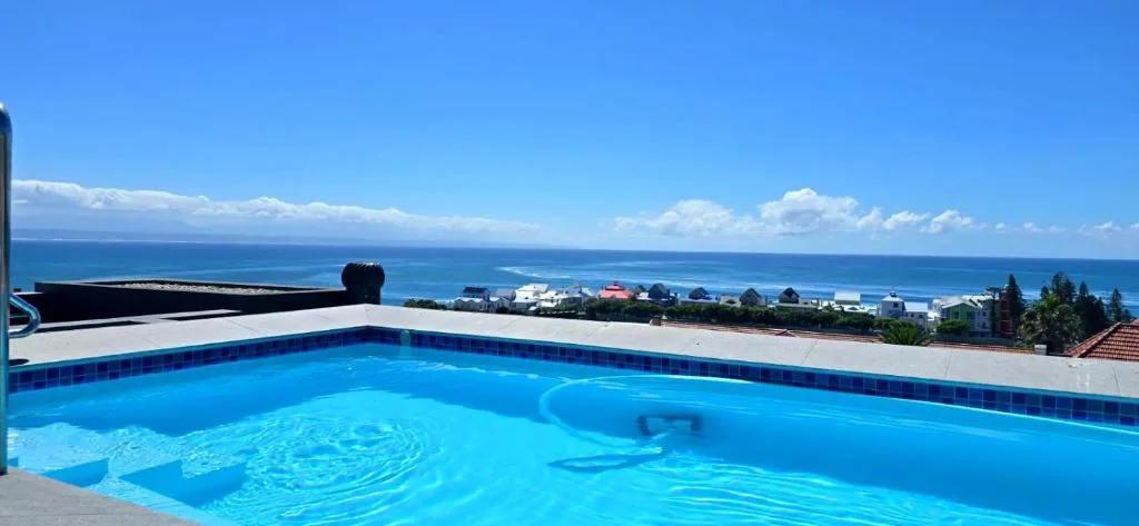 Swimming pool overlooking ocean and coastal town below