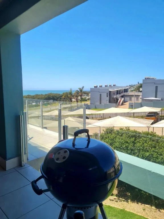Braai grill on deck overlooking ocean and coastal property gardens
