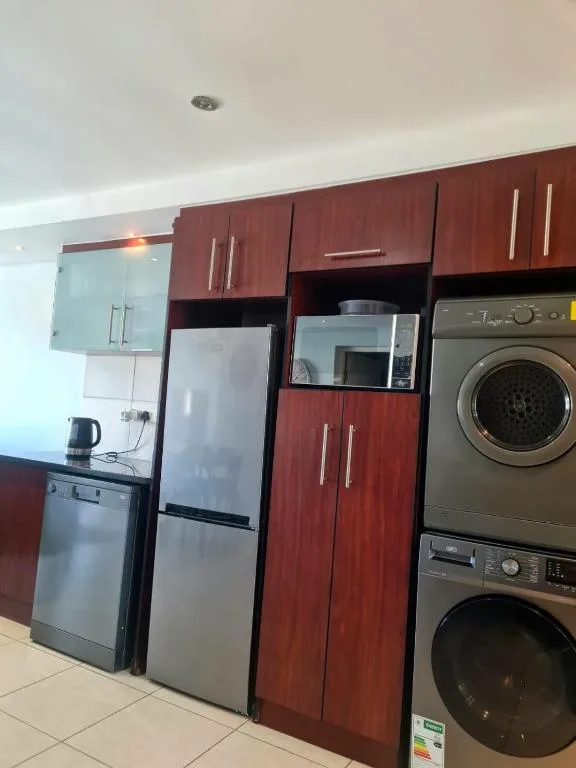 Modern kitchen with red cabinetry, stainless steel appliances and refrigerator