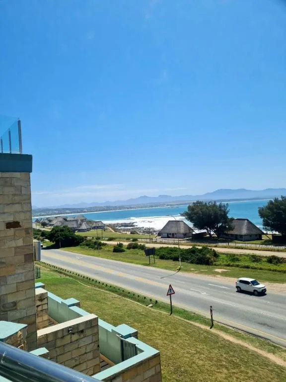 Panoramic coastal view of turquoise bay and mountains from property balcony