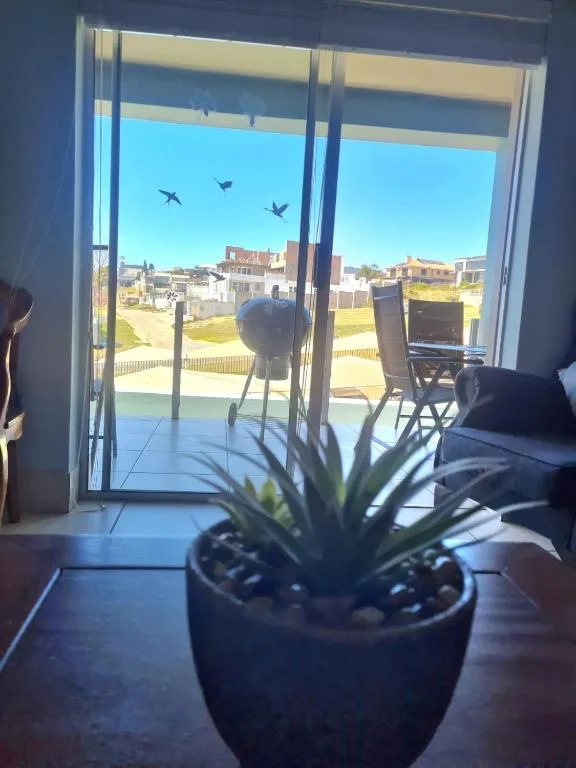 Scenic coastal town view through open glass doors from apartment interior