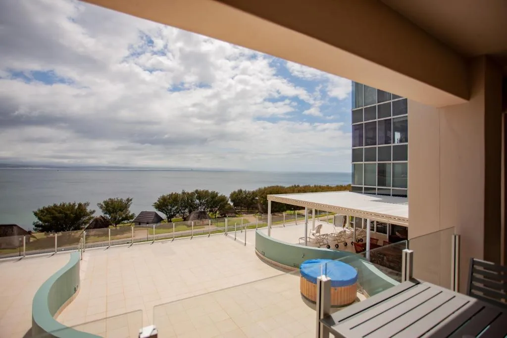 Expansive seaside deck with hot tub, ocean views, and coastal landscape