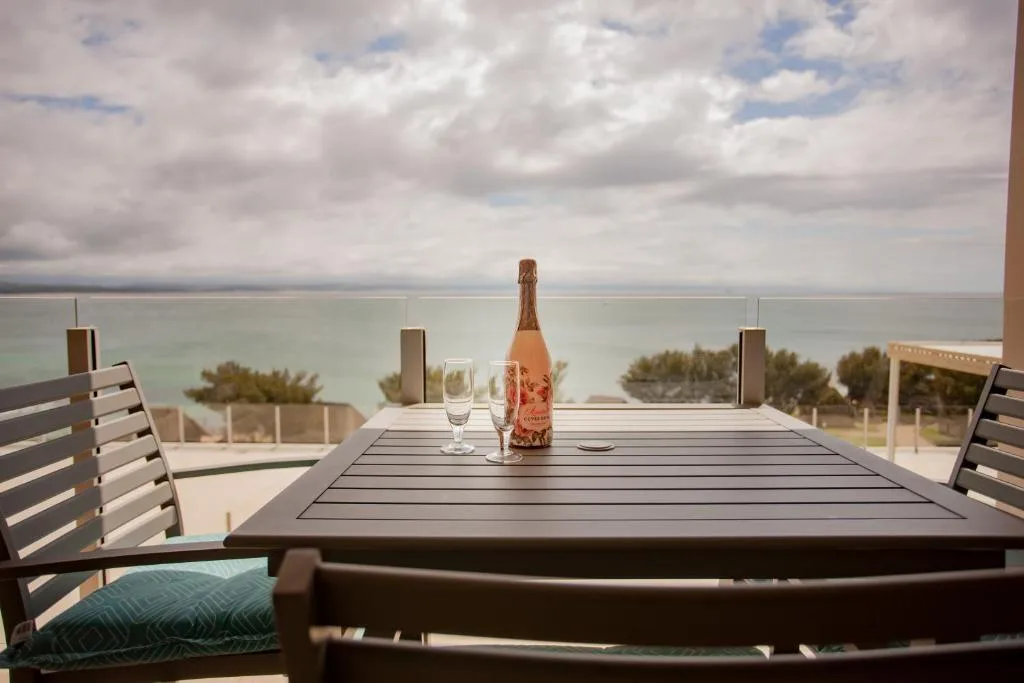 Outdoor dining table with ocean view and champagne bottle setup