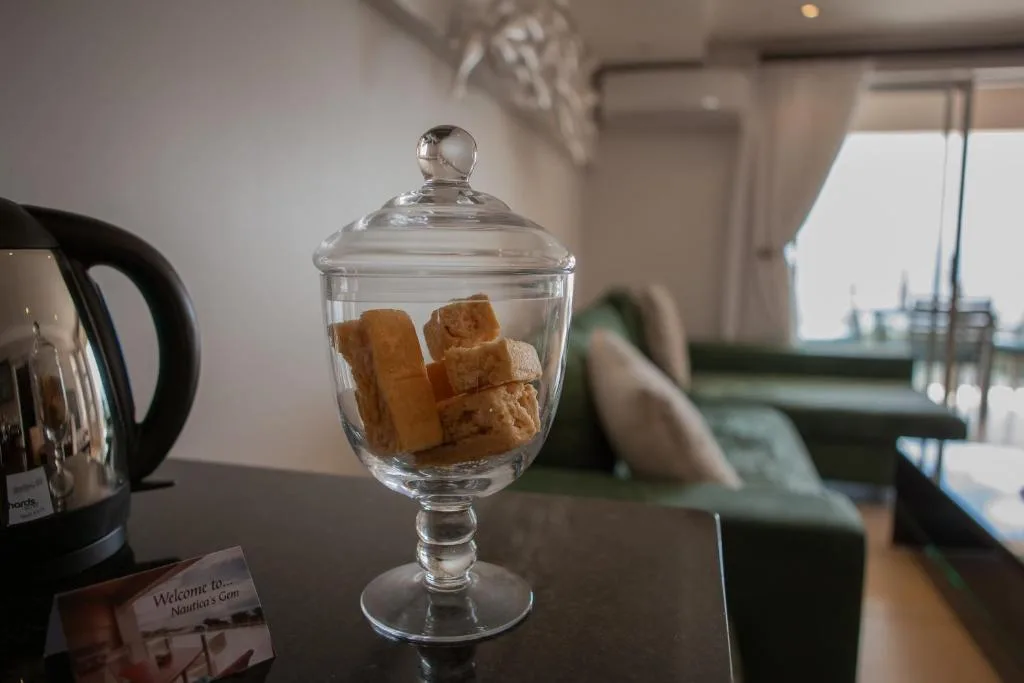 Glass jar with biscuits on kitchen counter, modern apartment interior
