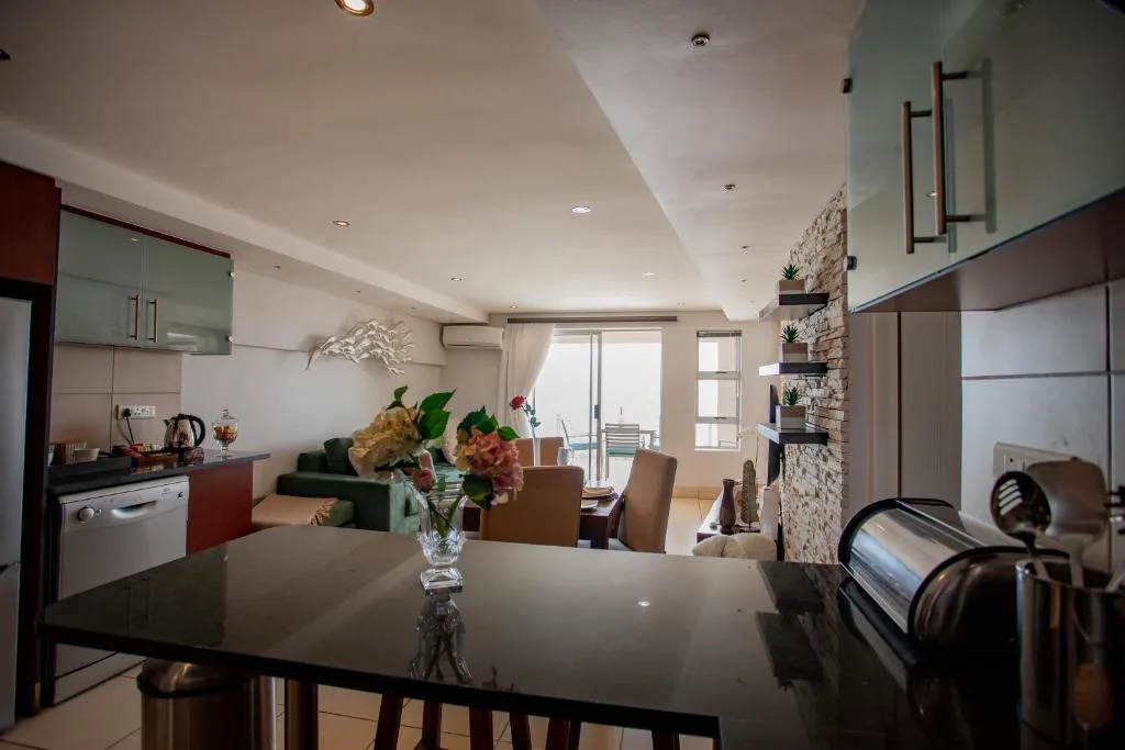Modern dining table with fresh flowers overlooking open-plan living space