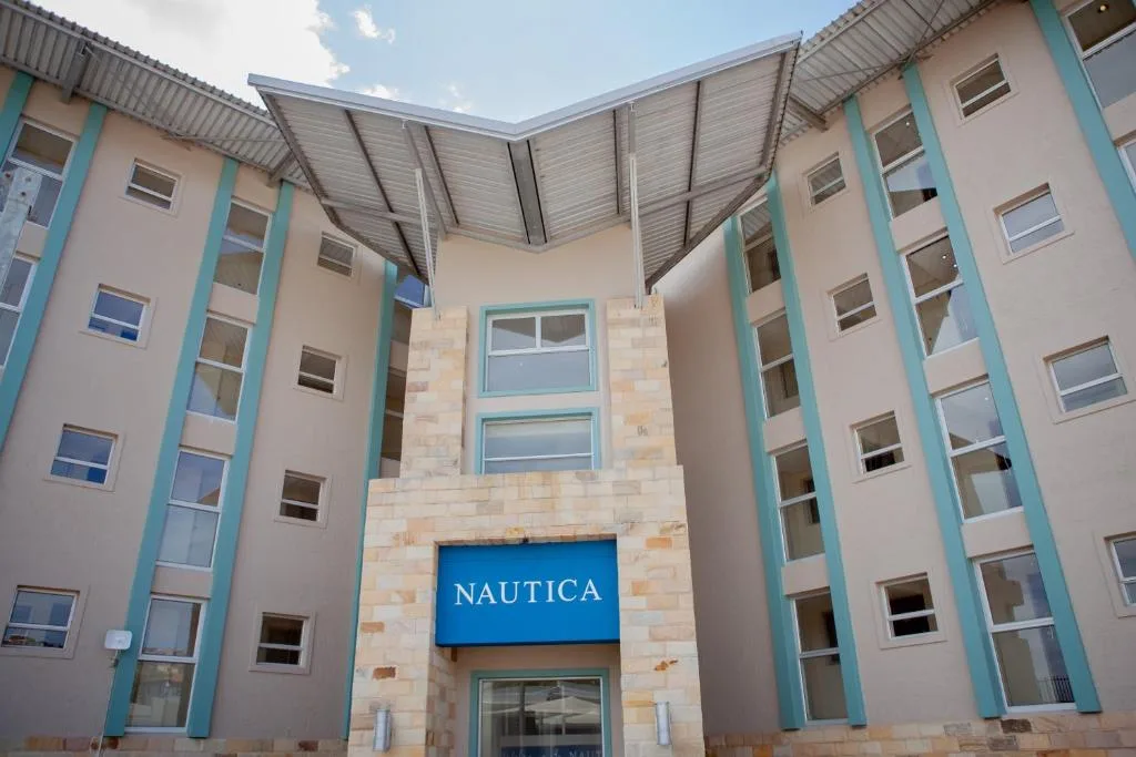 Modern apartment building with turquoise trim and central courtyard entrance