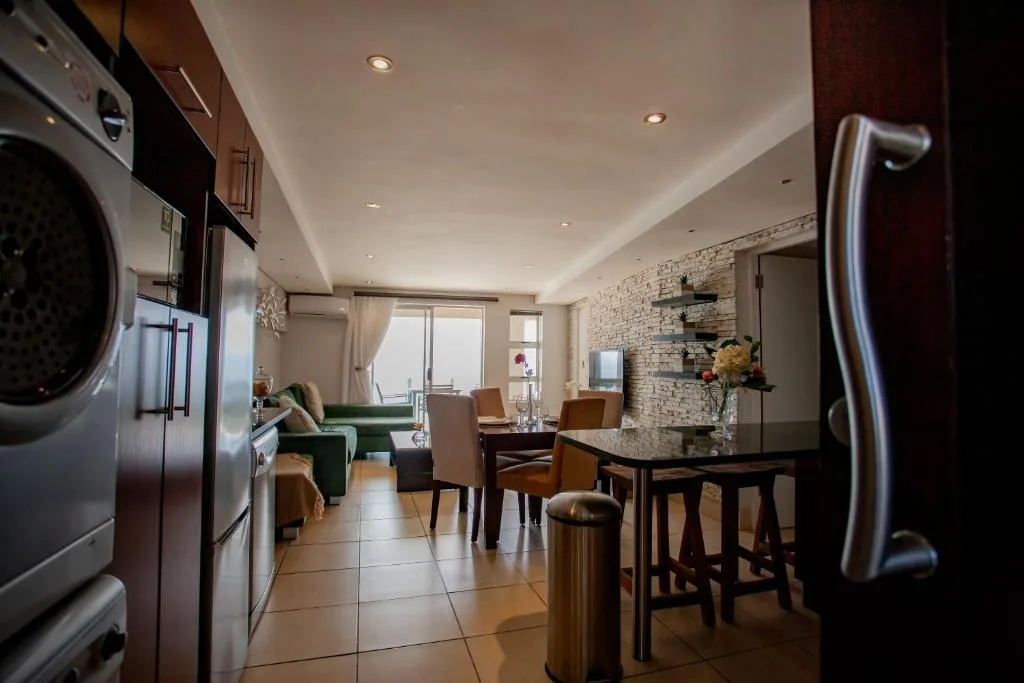 Modern kitchen with stainless steel appliances and open-plan living area