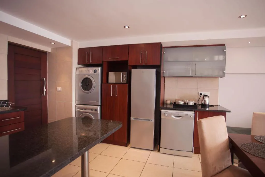 Modern kitchen with dark wood cabinetry, stainless steel appliances, and granite countertop