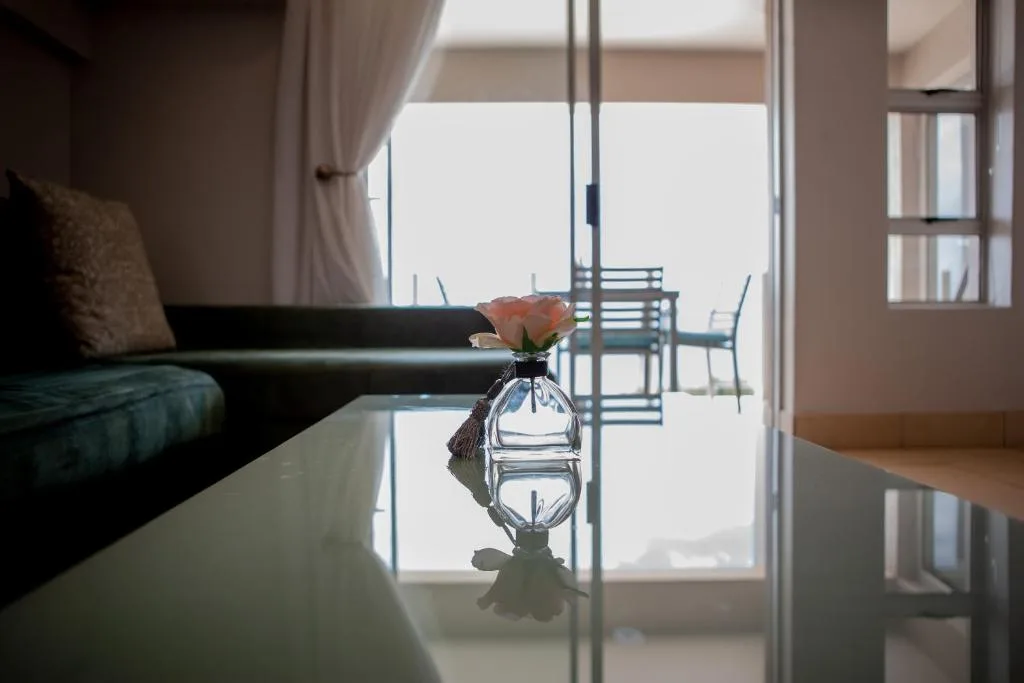 Modern lounge with sofa, glass table flower vase, ocean view through doors