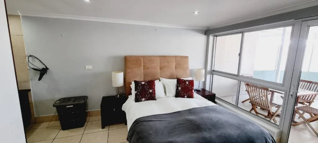 Spacious bedroom with queen bed, ocean view doors, and deck access