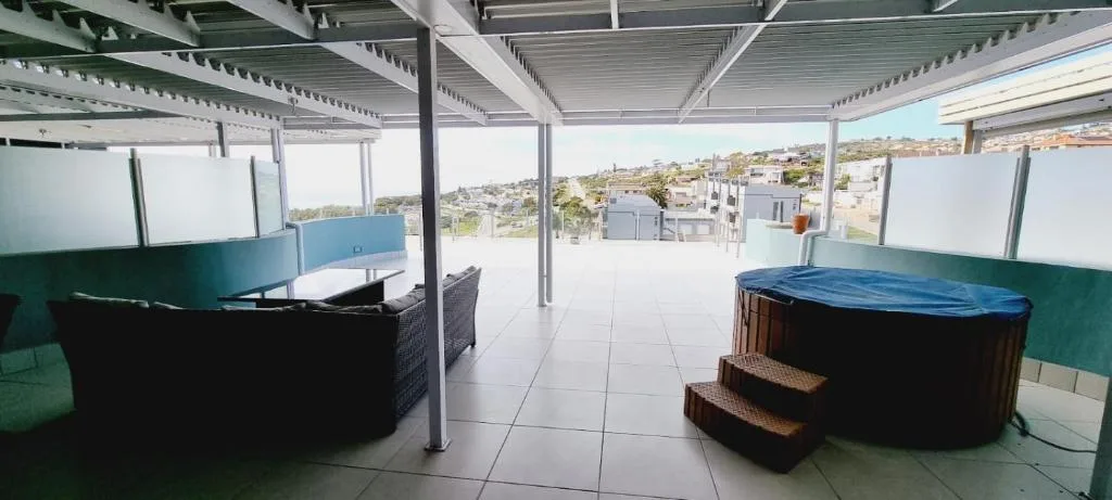 Rooftop deck with hot tubs, seating, and town views of Mossel Bay
