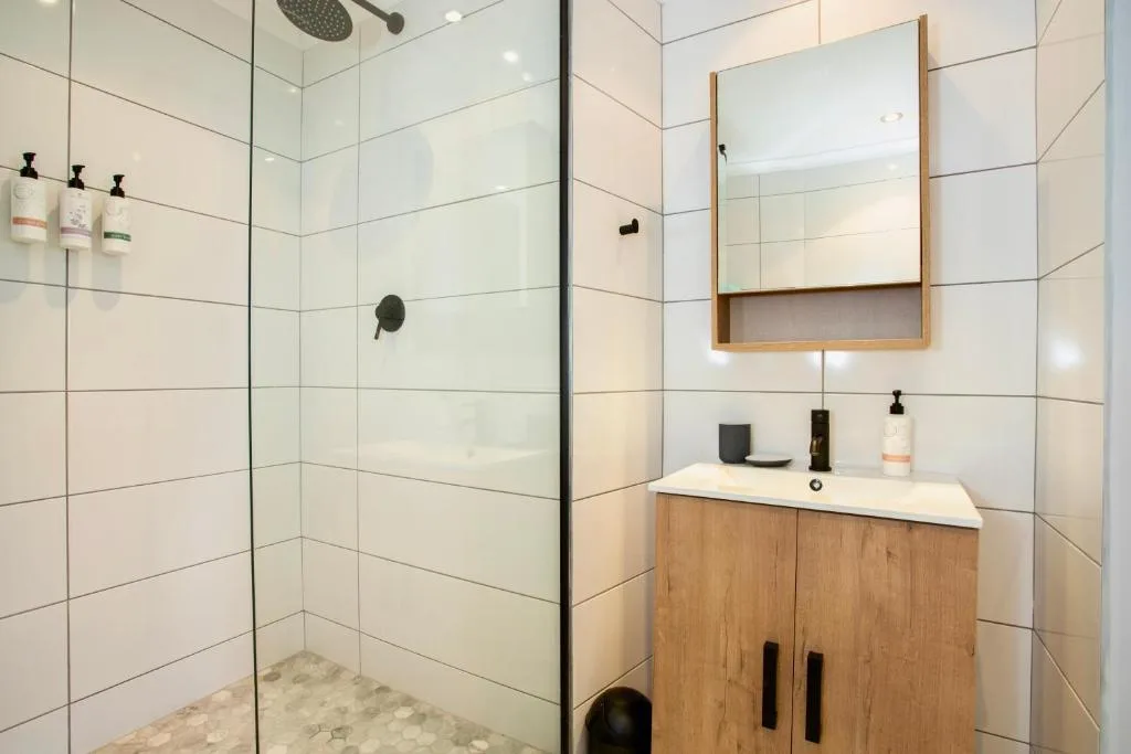 Modern bathroom with walk-in shower, wooden vanity, and mirror